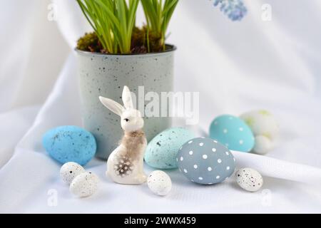 Easter composition with white rabbit and eggs on a white background. The minimal concept. Stock Photo