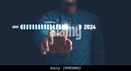 Businessman touch on loading progress from 2023 to 2024,Planning and challenge strategy in new year 2024 Concept. New business startup in 2024. New ye Stock Photo