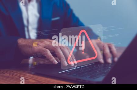 Businessman or programmer using laptop with triangle caution warning sign, coding, cryptography, hacker, crime, virus, for notification error and main Stock Photo