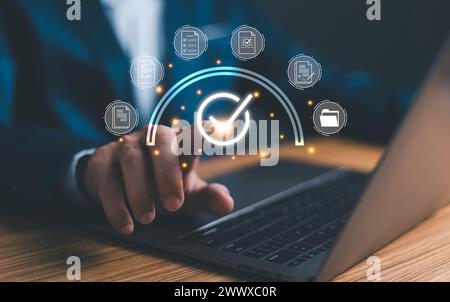 Businessman using laptop with correct sign mark and document icon for online approve paperless and quality assurance concept. Stock Photo