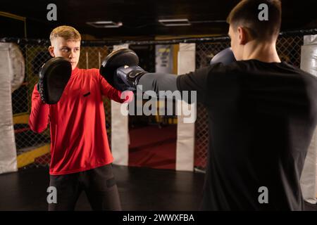 Young boxer training with his trainer during trains Stock Photo