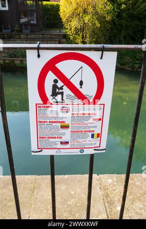 No fishing warning sign on a railing in multi lingual Eastern European languages. English, Lithuanian, Slovakian, Romanian and Polish. River Witham, W Stock Photo