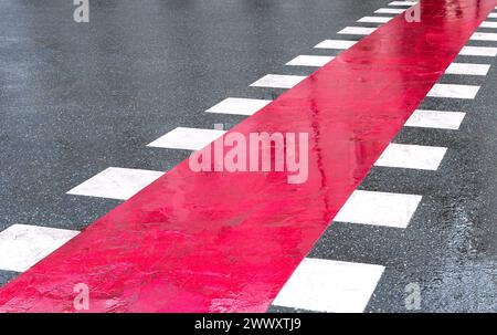 Pedestrian crossing for Bike Lane with white and red stripes on the asphalt road. Place to cross the road Stock Photo