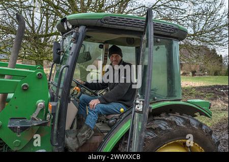 Young farmer in the tractor cab on his farm, Othenstorf, Mecklenburg-Vorpommern, Germany Stock Photo