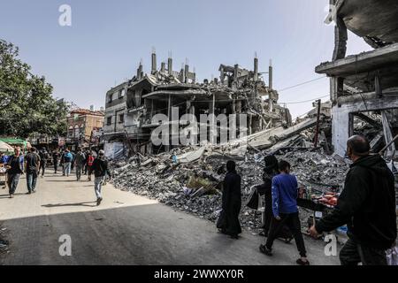 Rafah, Palestinian Territories. 26th Mar, 2024. Displaced Palestinians walk next to destroyed buildings, as Israeli air-strikes continue in Rafah. Credit: Abed Rahim Khatib/dpa/Alamy Live News Stock Photo