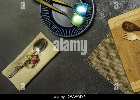 A still life with metal and wooden spoons on plates and napkins Stock Photo