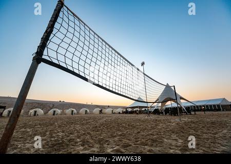 Silhouette of a volleyball net on the desert camp sealine Qatar. Beautiful Arabian adventures desert beach camp. Inland Sea Beach of the Qatar. Stock Photo