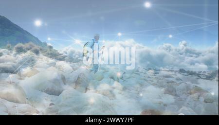 Caucasian senior man hiking in countryside, over fast moving clouds and network of connections. active outdoor lifestyle, healthy retirement and globa Stock Photo