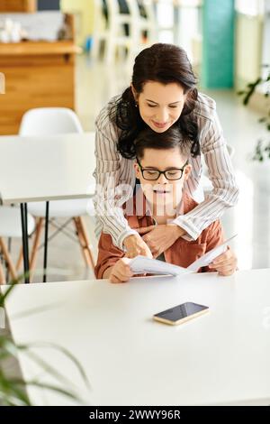 joyful mother in casual clothes with her inclusive son with Down syndrome looking at menu Stock Photo