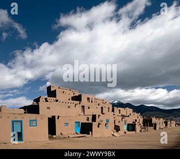 NM00696-00....NEW MEXICO - North House, with doors and ladder, Taos Pueblo tribal land. The Taos Mountains of the Sangre de Cristo Range are in the ba Stock Photo