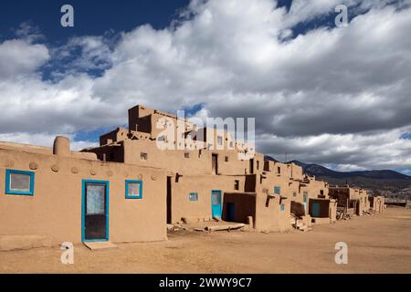 NM00695-00....NEW MEXICO - North House, with doors and ladder, Taos Pueblo tribal land. The Taos Mountains of the Sangre de Cristo Range are in the ba Stock Photo