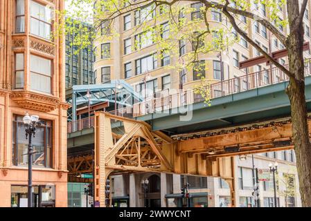 Elevated tracks and station between traditional high rise buildings in downtown Chicago on a sunny spring day Stock Photo