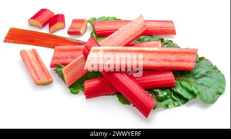 Red rhubarb stems' cuts over rhubarb leaves isolated on white background. Stock Photo