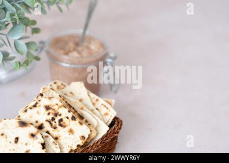 Handmade matzo in a wicker basket. Sweet condiment with apple-walnut ...