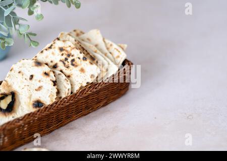 Handmade matzo in a wicker basket. Sweet condiment with apple-walnut ...