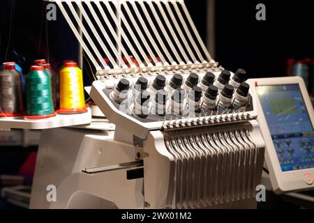 Single head multi needle industrial embroidery machine with touchscreen control panel. Selective focus. Stock Photo