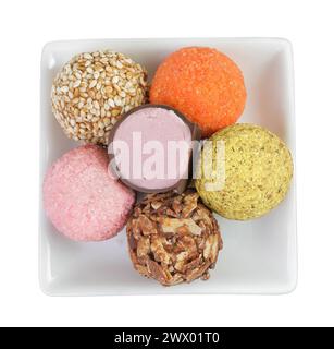 A variety of different truffles in a ceramic bowl Isolated on a white background. Top view. Flat lay Stock Photo