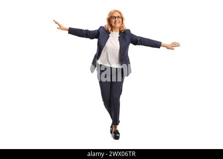 Full length portrait of a middle aged businesswoman walking on tiptoes and keeping balance isolated on white background Stock Photo