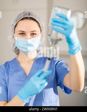 Nurse fills syringe with injection solution Stock Photo