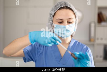 Nurse fills syringe with injection solution Stock Photo