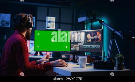 Freelancer works on isolated screen desktop computer on digital portfolio showcasing edited images. Photo editor selecting best photographs using retouching application on chroma key display Stock Photo