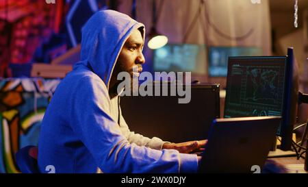 Hacker using VPN and darknet as anonymity tools to mask his online identity while committing data breaches. Cybercriminal in underground bunker masking his location hacking into servers Stock Photo