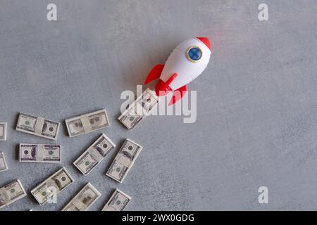 Rocket blasts off through a pile of money. Skyrocket sales, growing sales concept. Stock Photo