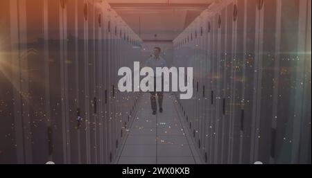 Composite image of caucasian male engineer walking in server room against night city traffic. Global networking and business storage technology concep Stock Photo