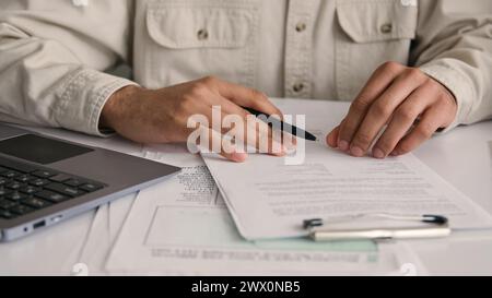 Unrecognizable man guy businessman using calculator and laptop calculate costs income money counting bills office paperwork check expenses write Stock Photo