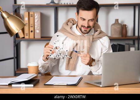 Male tutor with molecular model giving online Physics lesson at home Stock Photo