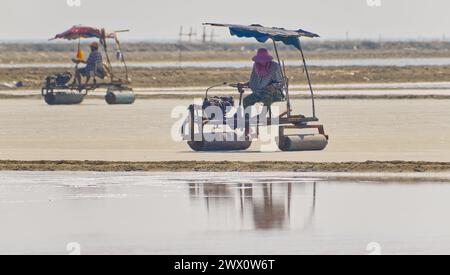 Roller machines operated by local workers on salt pans in rural southern Thailand Stock Photo