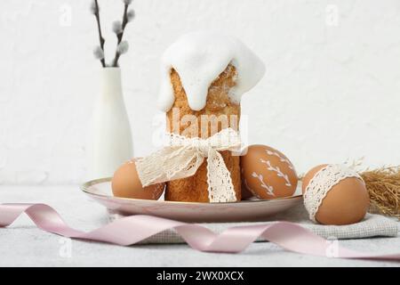 Plate with Easter cake, eggs and willow branches on white background Stock Photo