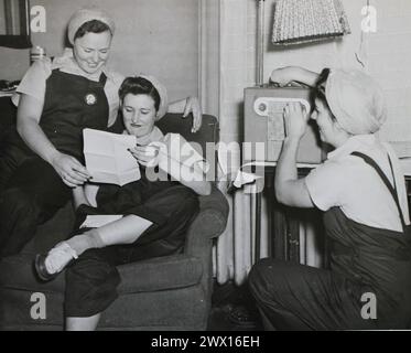 This photograph depicts three young workers as they read a letter and listen to the radio at a National Youth Administration dormitory ca. 1939-1943 Stock Photo