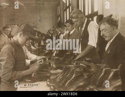 Manufacturing U.S. Army Shoes - Government inspectors making a final inspection of finished shoes at a manufacturing plant ca. 1918 Stock Photo