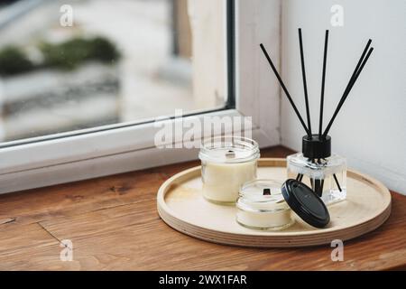 Scented Candles and Diffuser on a Wooden Tray by the Window Stock Photo