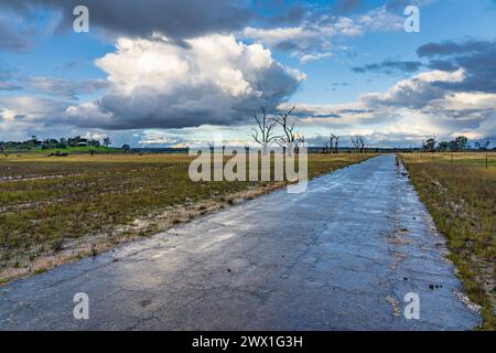 A deserted country road heading under a stormy sky to the horizon at Newstead in Central Victoria, Australia Stock Photo