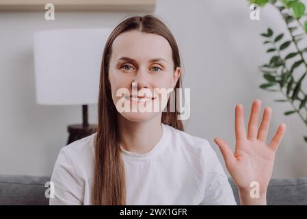 Close up of smiling young woman looking at camera, enjoying video virtual meeting with friends or colleagues, distant communication, smiling charming Stock Photo