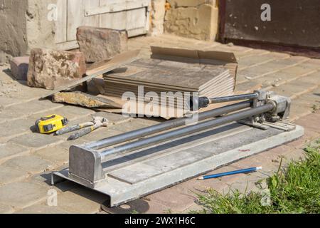 hand tool tile cutter with a bundle of ceramic tile at work, tile tools Stock Photo