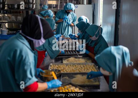 COOKIES PRODUCTION AHEAD OF EID Workers finish making cookies at the J&C cookie factory in Bandung, West Java, Indonesia March 27, 2024. During the holy month of Ramadan 1445 H, J&C cookies targets to produce 500 to 600 dozen cookies or 10,000 jars per day. Cookies are one of the specialties during Eid al-Fitr. IMAGO/KHAIRIZAL MARIS Bandung West Java Indonesia Copyright: xKharizalxMarisxKhairizalxMarisx COOKIES PRODUCTION AHEAD OF EID 15 Stock Photo