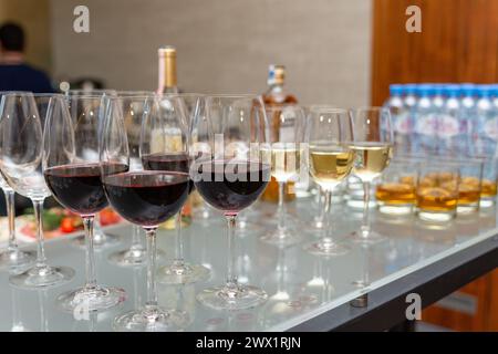 A lot of glasses with scotch, brandy and whine stand on the bar. Various alcoholic beverages in glasses at buffet on party. Stock Photo