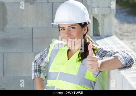 smiling female worker with thumbs up Stock Photo