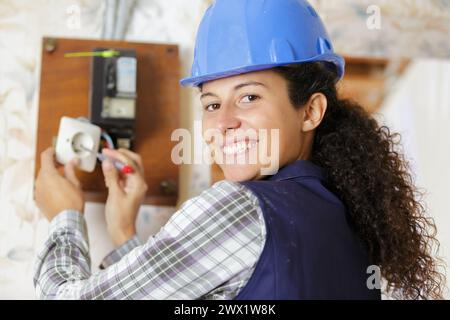 female electrician fixing socket electricity problem Stock Photo