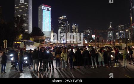 Family members of the hostages still in Gaza and their supporters hold signs as they block Ayalon highway, one of the Israel's major freeways, during a demonstration after the collapse of the latest round of hostage negotiations in Qatar and calling for a deal to free Israeli hostages held in the Gaza Strip on March 26, 2024 in Tel Aviv, Israel. Stock Photo