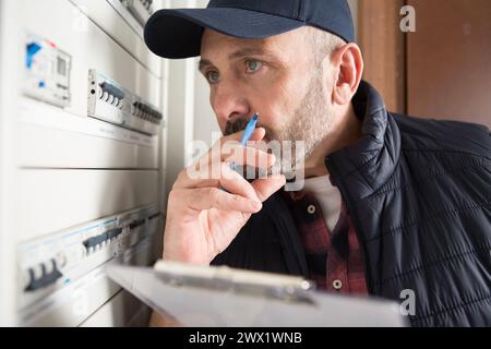 electrician installing energy saving meter Stock Photo