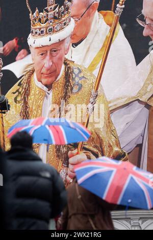 People gather in Piccadilly Circus, London, where an image of the coronation is displayed on a large screen. Stock Photo