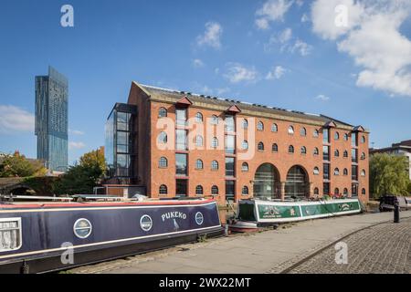 Merchants Warehouse in Castlefield, Manchester with canal boats moored up on the Bridgewater Canal in the foreground Stock Photo