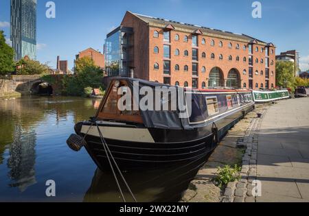 Merchants Warehouse in Castlefield, Manchester with canal boats moored up on the Bridgewater Canal in the foreground Stock Photo