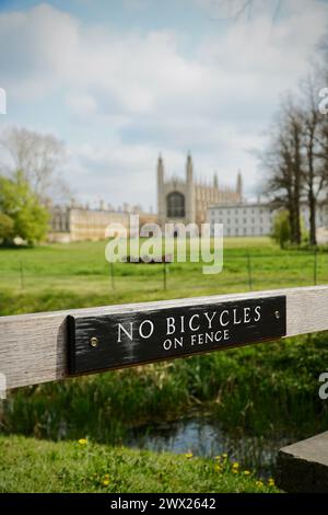 A photo of King's College Cambridge, taken from The Backs in summertime, featuring a wooden sign saying 'No bicycles on fence' Stock Photo