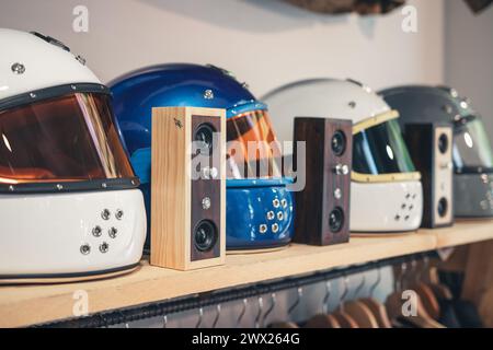 Shot of diagonal perspective of retro cafe racer motorcycle type helmets with homemade wooden bluetooth speakers in between Stock Photo