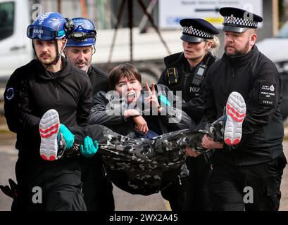 Sandwich, UK. 26th Mar, 2024. An activist is carried after refusing to walk following her arrest outside Instro Precision during the demonstration. Instro Precision provide components for Elbit Systemís weaponry. Palestine Action continues to target subsidiary companies of Israeli arms company Elbit Systems in an attempt to isolate them and make business impossible. This tactic has caused two of Elbit's ten main businesses to close in the UK and several partner companies to cut ties with them. Credit: SOPA Images Limited/Alamy Live News Stock Photo